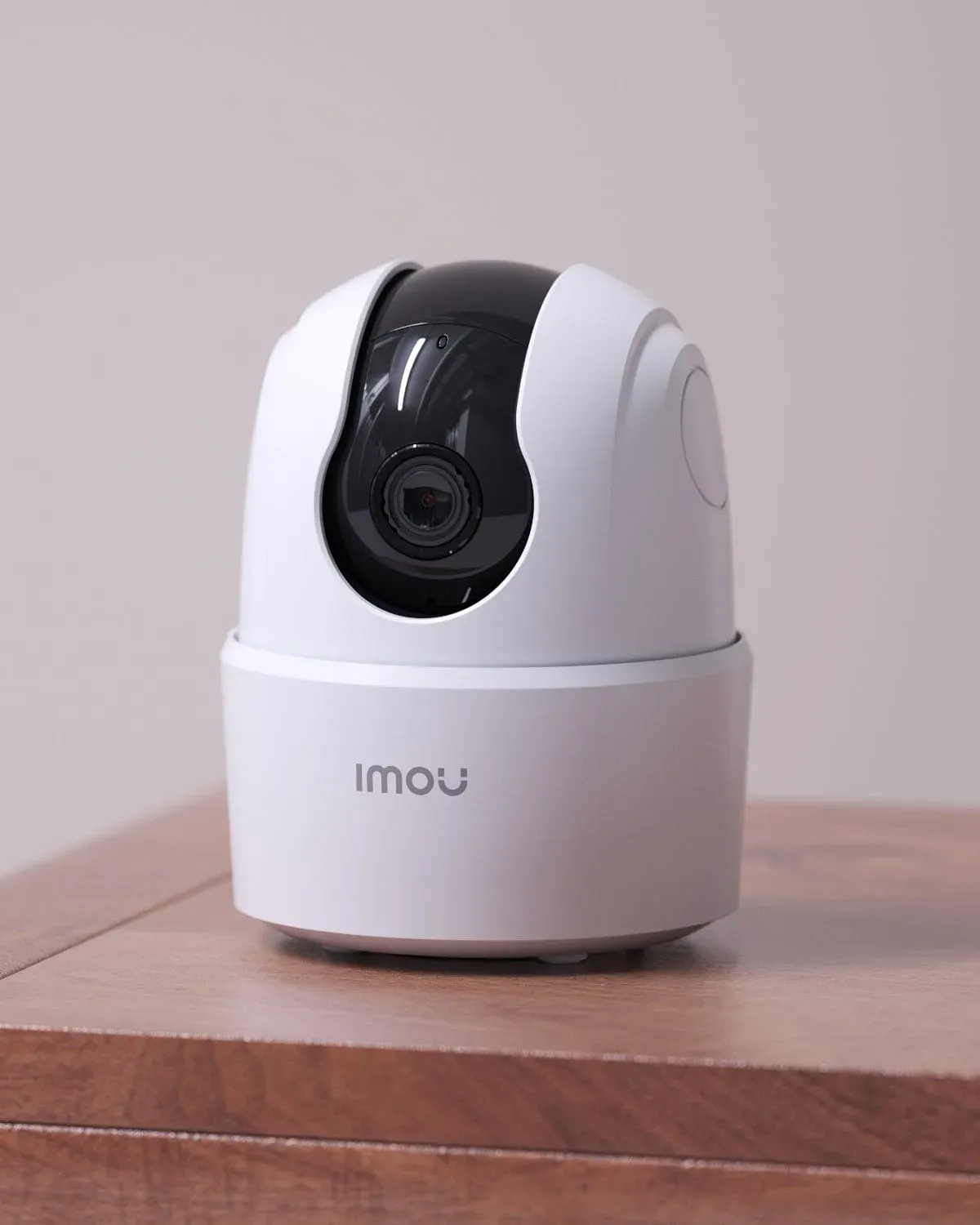 Imou Ranger 2C blanche posée sur un meuble en bois, devant un mur clair